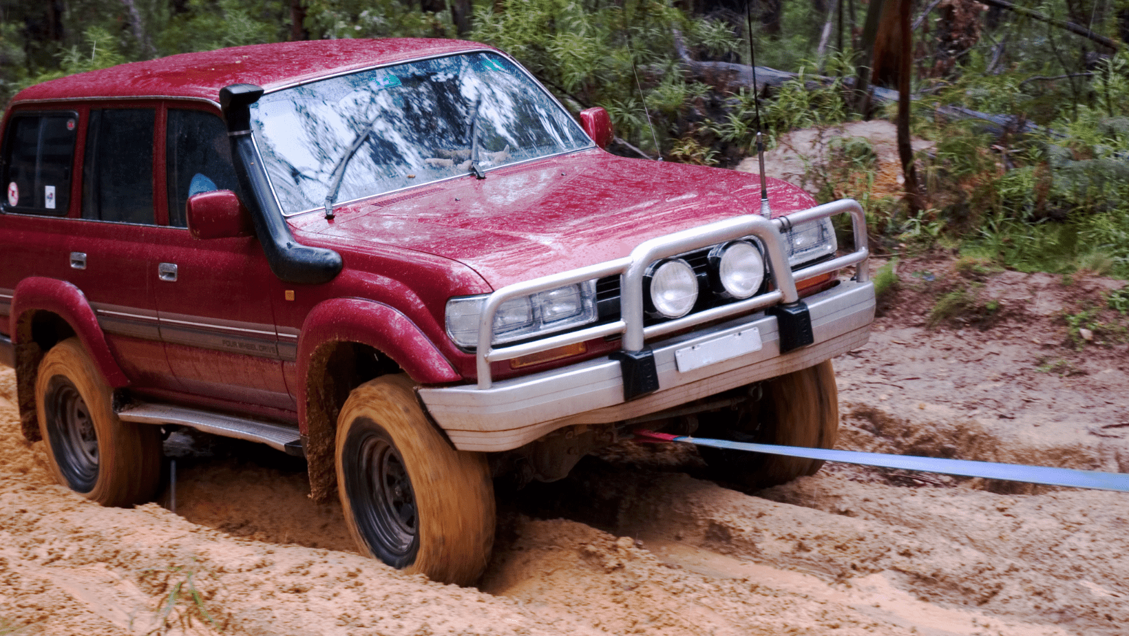 red 4 wheel drive on a dirt road